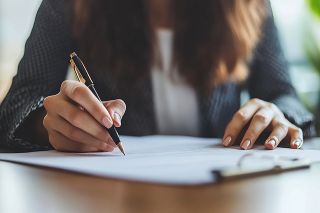 © Thongdee  - Adobe Stock.com Foto: Frau unterzeichnet Vertrag