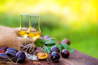 © Lumixera - stock.adobe.com Foto: Schnapsgläser auf Holztisch im Freien